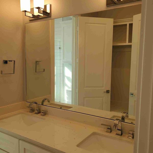 A huge mirror installed in elegant water sink area