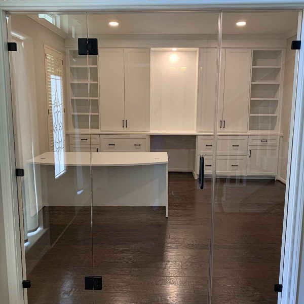 A wardrobe area with glass door and wall